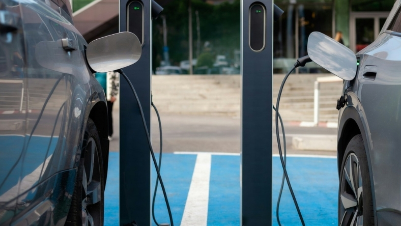 Two electric vehicles charging at public EV stations